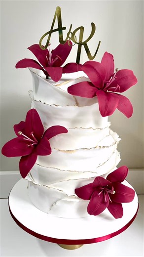 Irish Jane Javelona Rodriguez on Instagram: "Lovely wedding cake ❤️ with gumpaste Lilies in burgundy red."