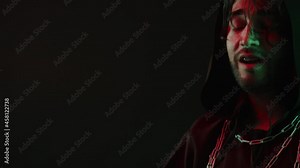 Evil exorcist dancing, making ritual close-up. Wicked shaman magician wearing robe and chains doing rite in darkness, scary wizard using witchcraft, black magic. Halloween concept.