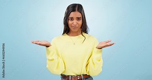 Why hands, woman and confused face with doubt, decision and choice with balance sign in studio. Thinking, question and comparison with female person portrait with problem solving and blue background