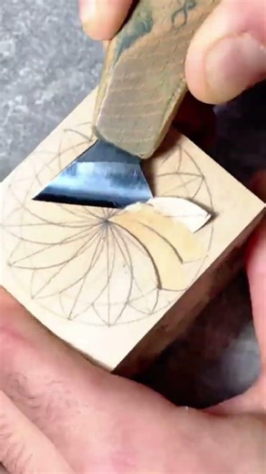 carefully chip carving a complex geometric pattern onto a wooden surface using a sharp carving tool