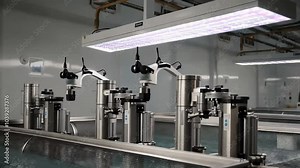A water treatment plant with robotic valves controlling the flow, screens filtering debris, and ultraviolet light systems disinfecting water.