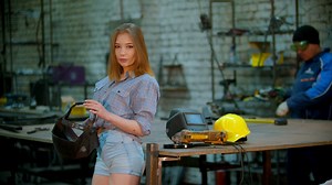 Woman putting on a welding mask in a blacksmith shop - Free Stock Video