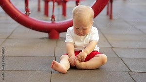 The child sitting and crying on the playground