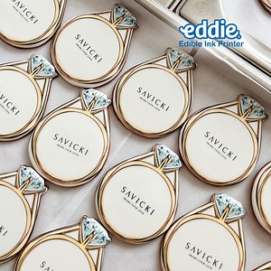 Eddie prints full-color photographs and text directly onto the surface of cookies, macarons, fondant, or other suitable food items. For example, the edible ink printer will hold up to twelve 3.5” (90mm) cookies on a circulating tray. Each cookie is automatically drawn into the printer one at a time. The printer then prints directly onto the surface of the item, rotates, feeds, and prints the next cookie. | Primera Eddie The Edible Ink Printer