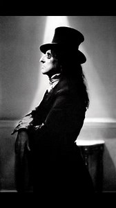 Alice Cooper (born Vincent Damon Furnier; February 4, 1948) is an American rock singer and songwriter whose career spans six decades. With a raspy voice and a stage show that features numerous props and stage illusions, Cooper is considered by music journalists and peers to be "The Godfather of Shock Rock". He has drawn from horror films, vaudeville, and garage rock to pioneer a macabre and theatrical brand of rock designed to shock audiences. Originating in Phoenix, Arizona, in 1964, Alice Coop