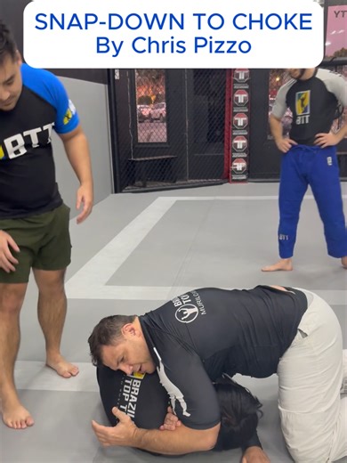 SNAPDOWN → CHOKE FINISH Professor Chris Pizzo demonstrates a powerful sequence from the front headlock position — turning a snapdown into a choke submission. From the front headlock, the key is controlling your opponent’s posture. By applying downward pressure and snapping the opponent toward the mat, you force them to carry your weight and expose their neck. Once the opponent’s posture breaks, you can quickly transition your grips and lock in the choke before they have a chance to recover their