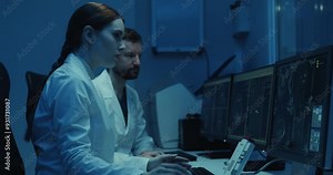 Radiologists work at a computer during an MRI or CT scan.