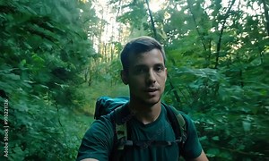 Hiker pauses for a selfie, enveloped by the vibrant greenery of a dense forest trail, capturing the spirit of adventure and solitude in nature.
