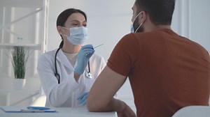 Free stock video - Female doctor uses a cotton swab to test a male patient for coronavirus.