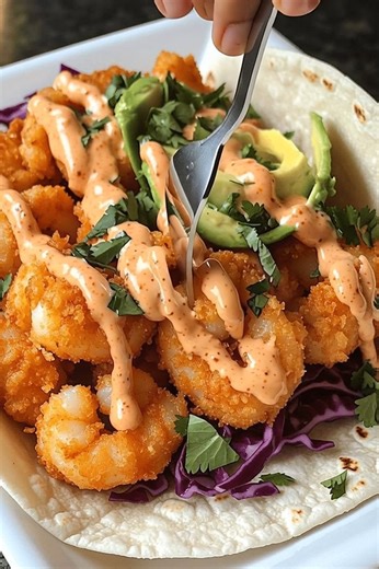 Crispy Shrimp Tacos with Spicy Cream Sauce 🌮🔥 Ultimate easy weeknight meal — crunchy, creamy, and irresistible! 📝 Ingredients: 1 lb (450 g) shrimp, peeled and deveined 1 cup flour 1 cup panko breadcrumbs 2 eggs, beaten 1 tsp paprika 1 tsp garlic powder Salt and pepper to taste Vegetable oil (for frying) 4 small flour tortillas 1 cup shredded red cabbage 1 avocado, sliced 2 tbsp fresh cilantro, chopped For the spicy sauce: ½ cup mayonnaise 1 tbsp sriracha 1 tsp lime juice 🍴 How to prepare it: