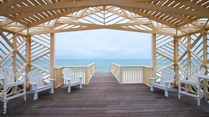 Point of view pov handheld walking shot of wooden pavilion gazebo by beach sea ocean of Gulf of Mexico at Seaside, Florida with new urbanism white wooden architecture, people on coast shore Stock Video