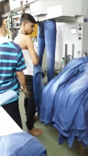 Denim jeans steam pressing in garment factory
