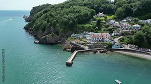 Babbacombe, South Devon, England: DRONE VIEWS: The drone circles Babbacombe beach and harbour wall as a tourist boat sails the coastline. Babbacombe is a popular UK holiday destination (Clip 15).