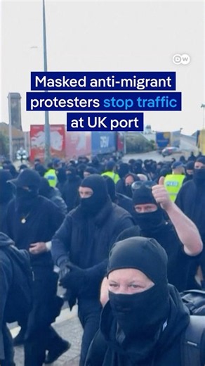 A group of masked people stops traffic at UK port | DW News
