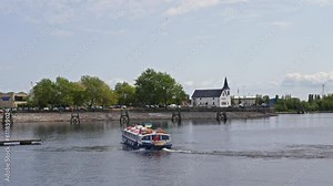 Cardiff, UK - May 16 2023: A blue tour boat turning around at Cardiff Bay