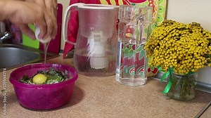 Preparation of cutlets from beet tops. A man mixes beet tops, flour and a chicken egg in a container. Regional food.