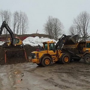 Volvo Construction Equipment L70F wheelloader loading an Volvo Construction Equipment - Europe, Middle East and Africa A25C rock truck with gravel, and an Volvo EC210B excavator with an engcon tiltrotator, sorting the dirt on a grizzlybar, on a recycling station in Strömsund in Sweden. | Danish Construction Channel