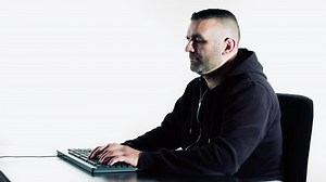 Hacker typing on black keyboard, white background 4k