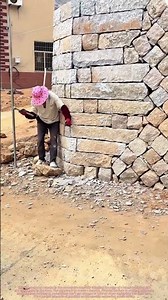 Crafting a Safe Curve: A Mason Smooths a Retaining Wall on a Mountain Turn