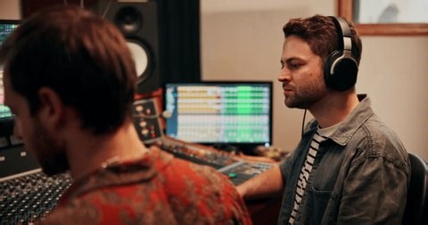 clip-4045982575-production-talking-producers-headphones-music-studio ...