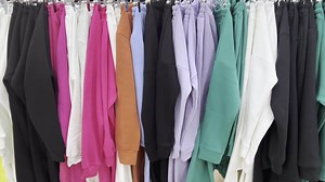 Download Clothes of different colors hang on hangers in store. for free
