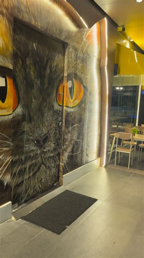 Escape to Uno Cat Café & Restaurant! The soft, light colors blend seamlessly with the relaxing view, creating the perfect spot to unwind. Gaze at the bright, inviting chandelier and feel yourself instantly relax. The iconic door beckons you into a world where everything is just right. Cats, delicious food, and a unique ambiance – it's all here, waiting for you. | Uno Cat Café & Restaurant