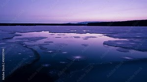 The peacefulness of a frozen lake at twilight with no signs of movement or life except for the occasional gust of wind.