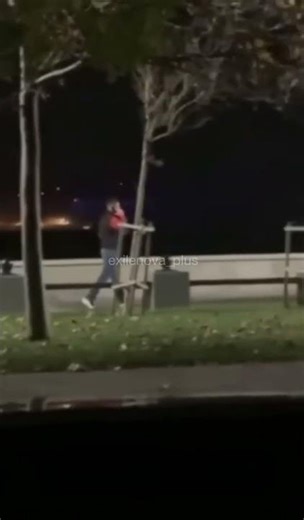 strolls against the backdrop of machine gun fire in the night sky.