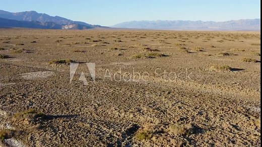 Drone flight over vast rough terrain covered with salt pans at Badwater basin of Death valley National Park. Aerial.