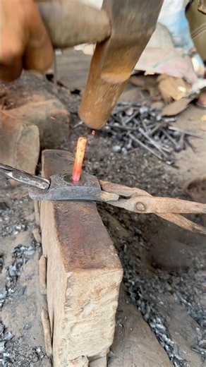 Forging heavy industrial iron nails inside an authentic American blacksmith shop