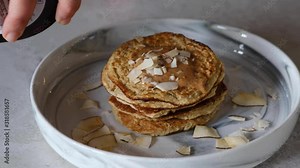 Pouring Maple Syrup on homemade healthy pancakes. Delicious breakfast with oatmeal banana gluten free pancakes. Stock Video