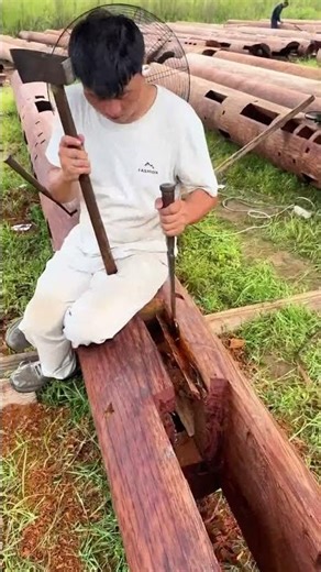 The process of crafting wooden beams for a log cabin.