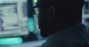 Close Up Portrait of Black Male Programmer Looking at Desktop Computer Display Monitors. Professional Developer Writing Code, Working on High Tech Project. Coding and Developing Job Concept