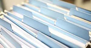 Woman hands are sorting through documents in folder in archive closeup. Organization of corporate document flow and documentation