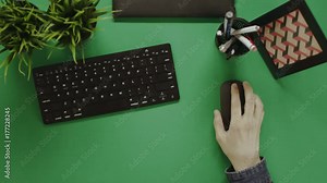 Top down shot of man scrolling mouse wheel and drinking coffee