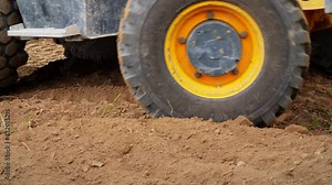 Excavator working. Backhoe operating in a Land. Wheels close up