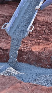 Foundation worker pouring ready mix cement concrete for building in construction site