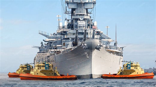 Massive US battleship towed out to sea by strong tugboats