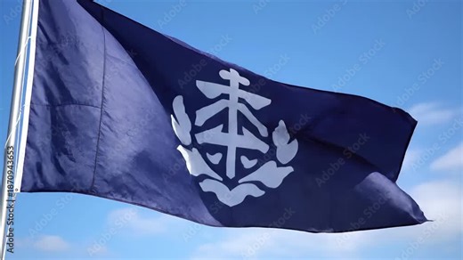 A vibrant blue flag featuring the distinctive white emblem of the Blue Flag certification program proudly waves against a clear azure sky symbolizing environmental excellence and high quality standar.