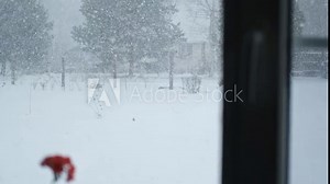 Winter view from a window. It`s snowing outside. Snow Falling in Slow Motion. Winter landscape seen through the window. Picturesque fabulous atmosphere of Christmas. Holiday season. Snowstorm. Stock Video