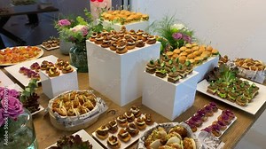 Table with a variety of appetizers and tapas of different flavors such as chicken, meat, roast beef and baos.
