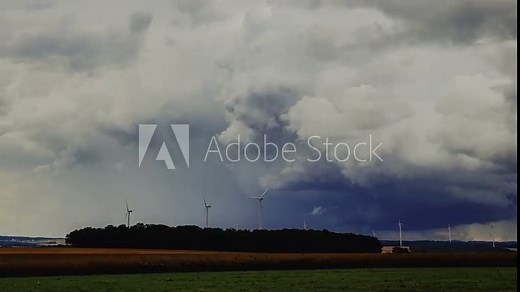 time lapse of massive storm clouds forming over wind turbines in HDR HLG