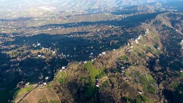 Aerial view of scattered village houses spread across low hilly countryside landscape. Rural settlement pattern shows isolated homes farmland patches and natural terrain from above Stock Video Footage - Alamy