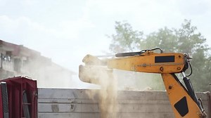 Digger excavator working and loading dust sand material rock loading a truck in slow motion