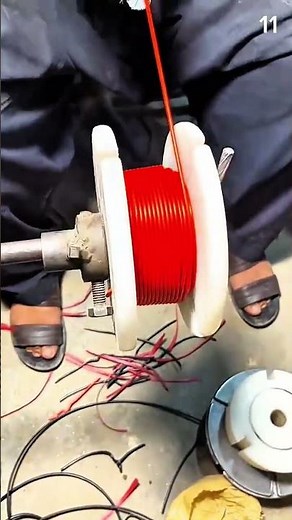 Winding red wire onto spool using hand crank
