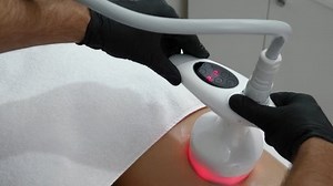 Anti-cellulite thigh machine cosmetology. Program for health and slimming. Hardware figure correction. Apparatus massages of female hip close-up