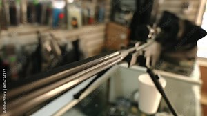 Sniper rifle selling on the counter of the weapon store. Close-up slow motion dolly shot along the trunk