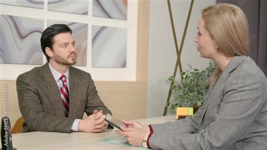 Portrait of confident man job seeker and pretty female human resource manager with tablet pc discussing job requirements, salary and duties while hiring candidate to executive position at office.