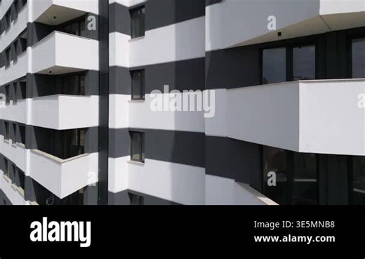 Close-up drone video of a contemporary apartment building facade. Abstract geometric pattern of white balconies and dark grey walls in a modern residential complex Stock Video Footage - Alamy