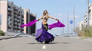 Young beautiful girl dancing oriental dances against the backdrop of the city